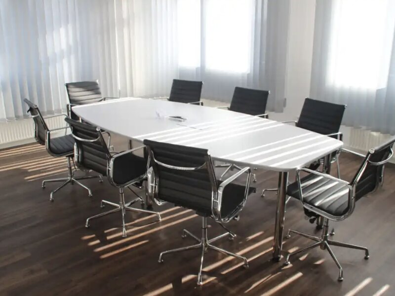 Contemporary boardroom with white meeting table and mesh task chairs