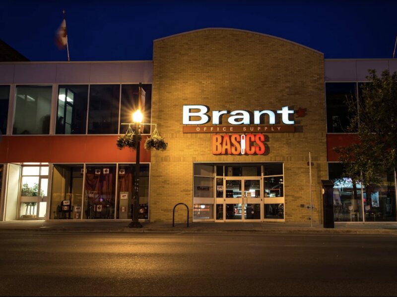Brant Basics storefront at night with illuminated red signage